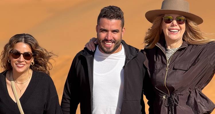 Drie mensen die samen poseren in een woestijnlandschap.