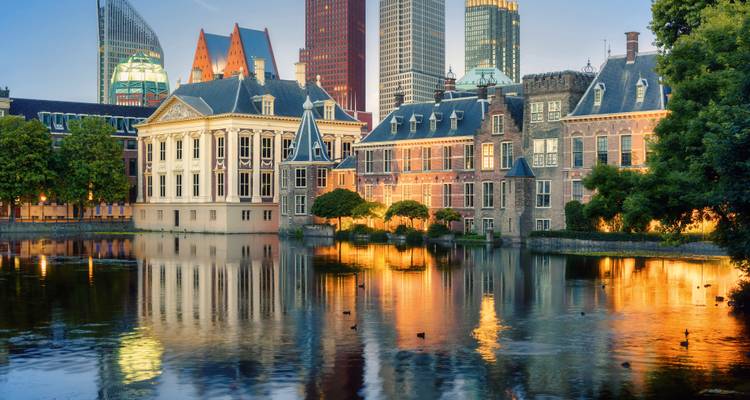 Edificios históricos reflejados en un estanque al anochecer.