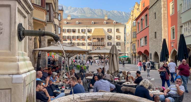 Des gens qui dînent dehors avec des montagnes en arrière-plan.