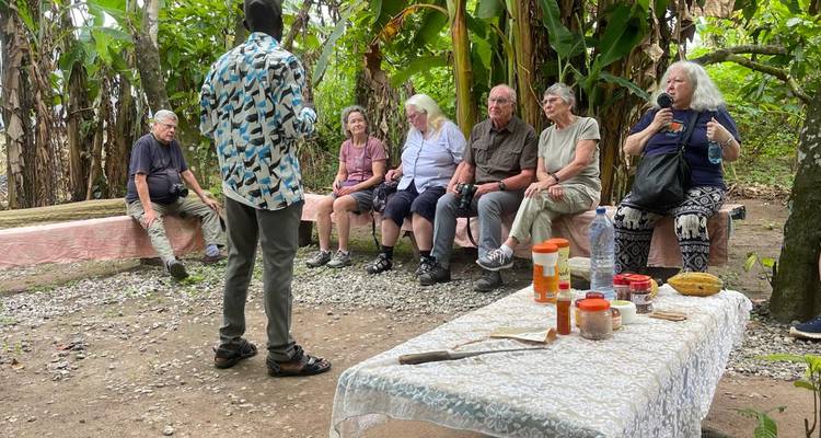Gruppe sitzt im Kreis im Freien mit einem sprechenden Führer.
