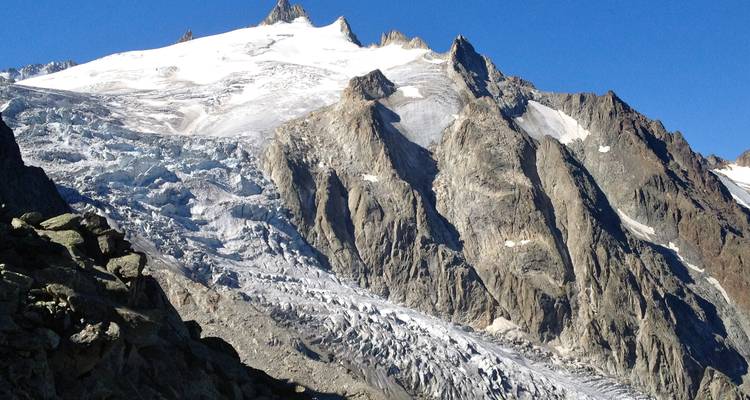 Vista detallada de una montaña rocosa con un glaciar.