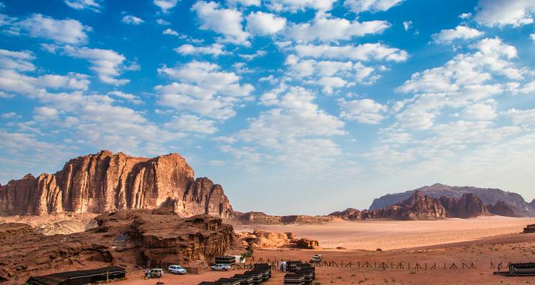 A landscape of Wadi Rum desert with sandstone mountains and a clear blue sky.