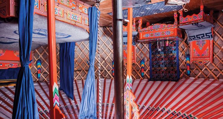 Intérieur aux couleurs vives d'une yourte mongole avec des motifs colorés et des tissus suspendus