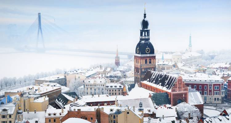 Vue aérienne d'une ville enneigée avec une cathédrale proéminente.
