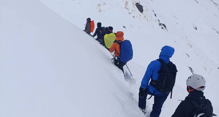 Un grupo de personas escalando una montaña nevada.