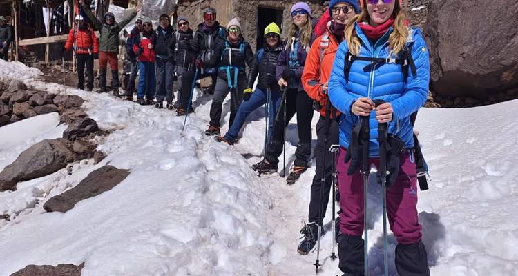 Un grupo de personas posando with equipo de senderismo en la nieve.
