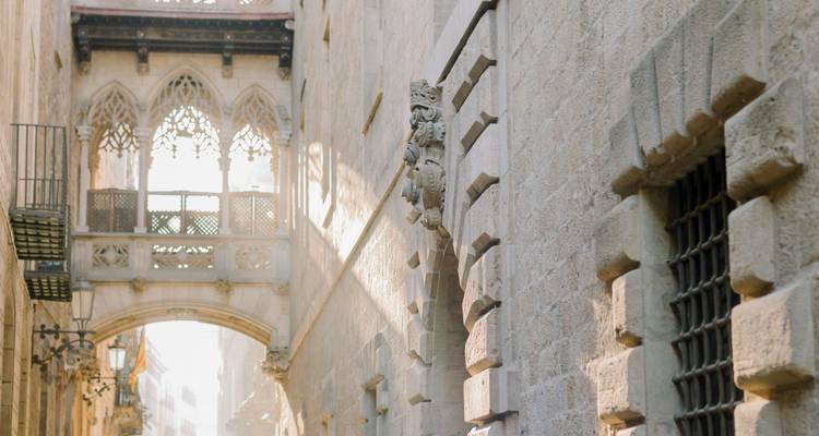 Stone alley with ornate gothic balcony lit by warm backlight