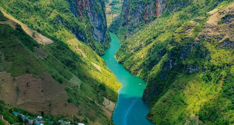 Torenhoge kliffen met een rivier die door een weelderig landschap stroomt.