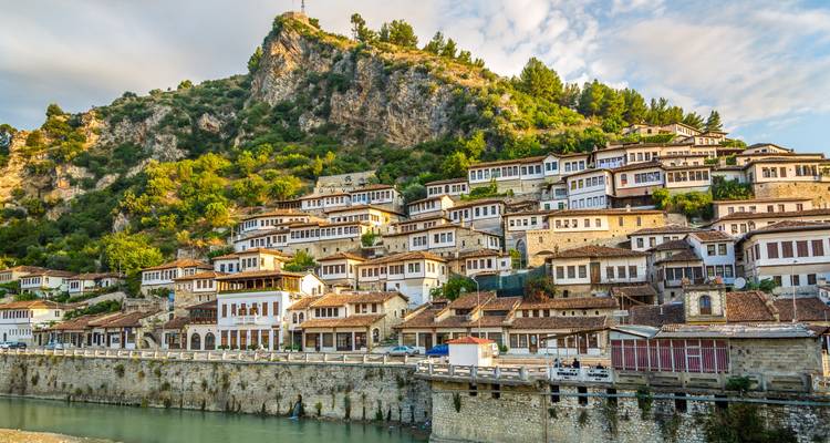Charmante ville à flanc de colline avec une architecture traditionnelle et une rivière à proximité.