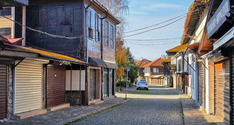 Rue pavée dans un village traditionnel avec des bâtiments en bois.