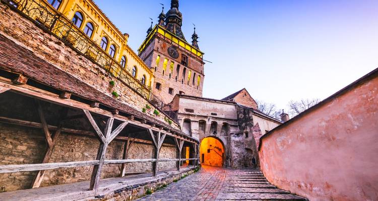Sighișoara Klokkentoren bij schemering met historische gebouwen.