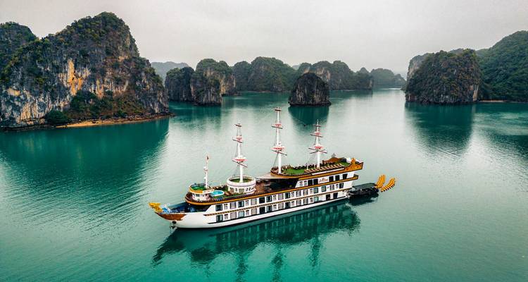 Cruiseschip in een baai omgeven door kalkstenen karstformaties.
