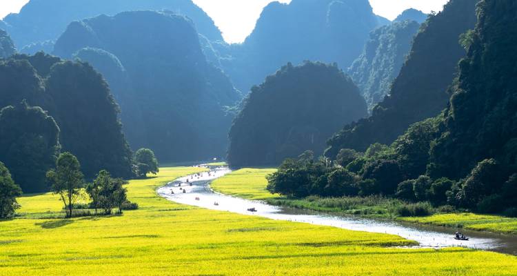 Rivier die door een vallei stroomt met weelderige vegetatie en karstbergen.