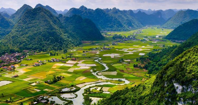Panoramisch uitzicht op een weelderige groene vallei met bergen.