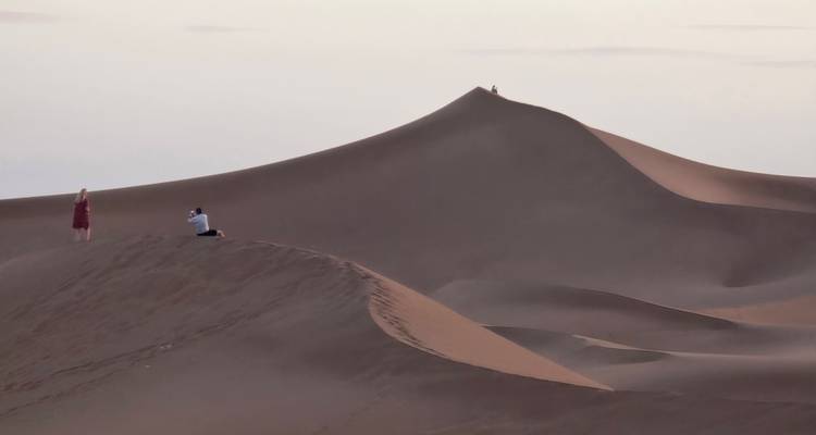 Fotografen die torenhoge duinsilhouetten vastleggen in zacht schemerlicht