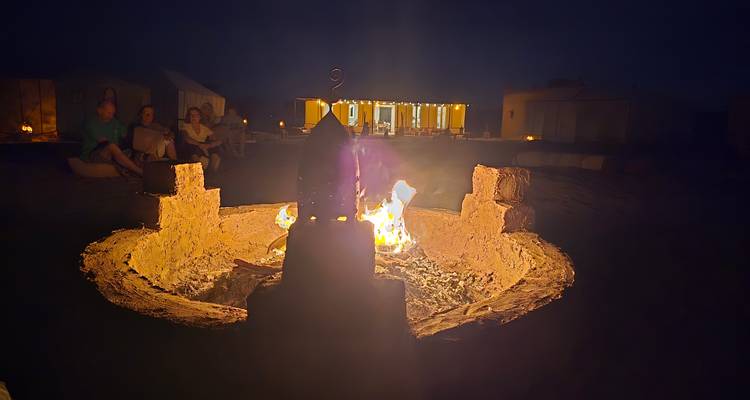 Nachtelijke kampvuur bijeenkomst in een woestijnkamp met gloeiende lantaarn als middelpunt
