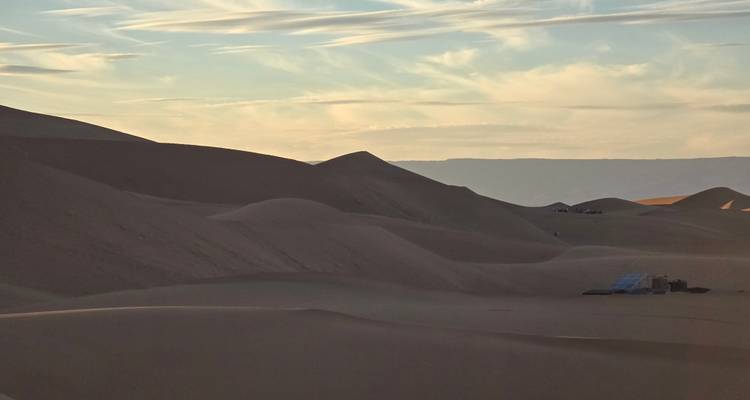 Zachte woestijnruggen in zacht avondlicht met verre bergen