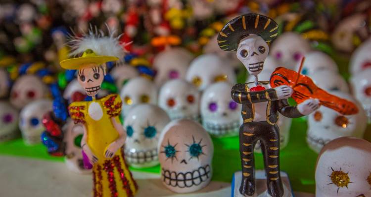 Colorful Day of the Dead figurines with elaborate decorations.