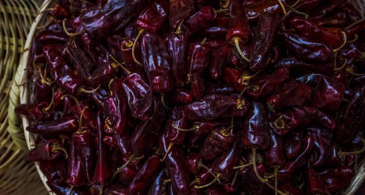 Cesta llena de chiles rojos secos en un mercado.