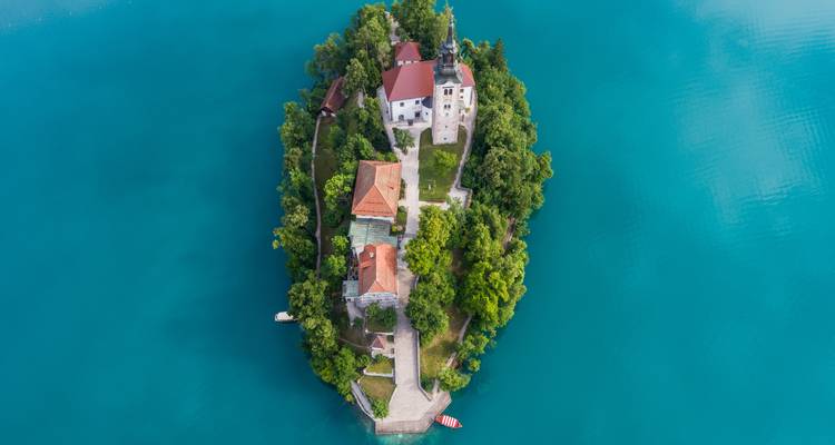 Vista aérea panorámica de una isla con una iglesia en el medio de un lago.
