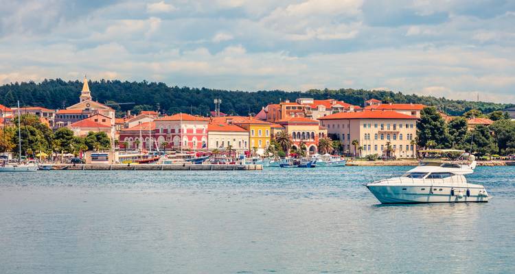 Barco en un puerto con edificios históricos coloridos de fondo.