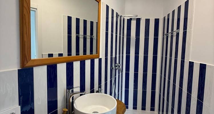 Salle de bain avec carrelage rayé et un lavabo moderne.