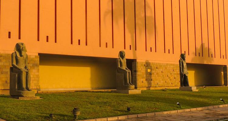 Vista exterior de un museo con estatuas del antiguo Egipto en exhibición.