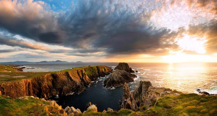 Spectacular sunset over jagged sea stacks and crashing waves on Ireland’s wild coast