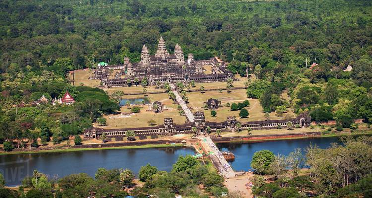 Aerial view of ancient temple complex surrounded by lush green forest.