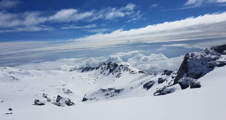 Paisaje alpino cubierto de nieve en el Kilimanjaro con crestas escarpadas bajo un cielo dramático