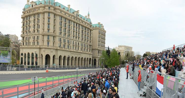 Gradas abarrotadas en el Circuito de la Ciudad de Bakú con un edificio prominente al fondo.
