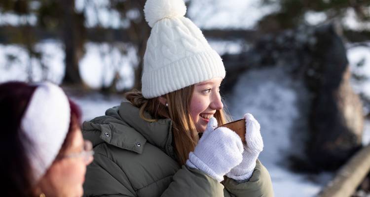 Deux personnes en vêtements d'hiver, souriantes, avec un arrière-plan enneigé.