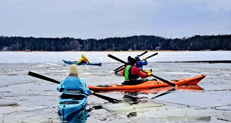 Groupe de personnes faisant du kayak dans une eau glacée.