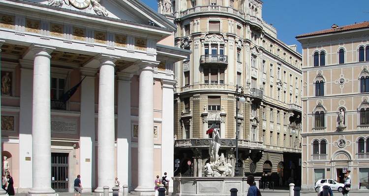 Una zona costera con un puente en una ciudad europea bajo un cielo brillante.