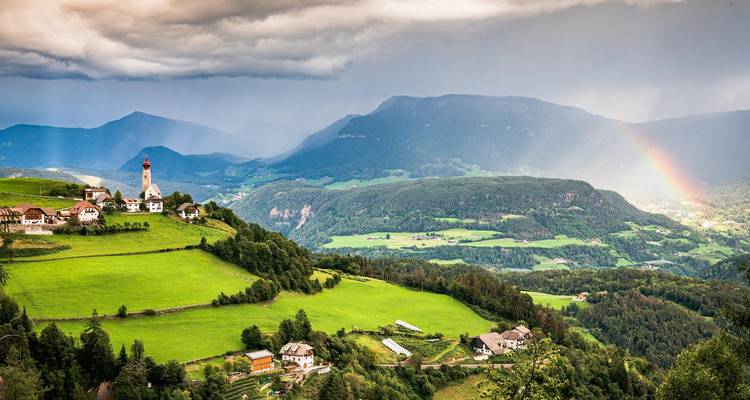 Una abadía ornamentada encaramada en una colina con un telón de fondo de cielo azul claro.
