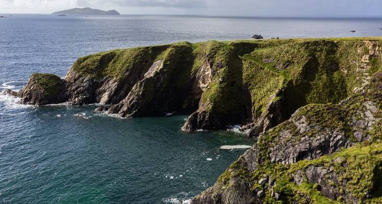 Vue depuis la falaise du littoral avec la mer bleue et des îles au loin, possiblement à Dingle, en Irlande.