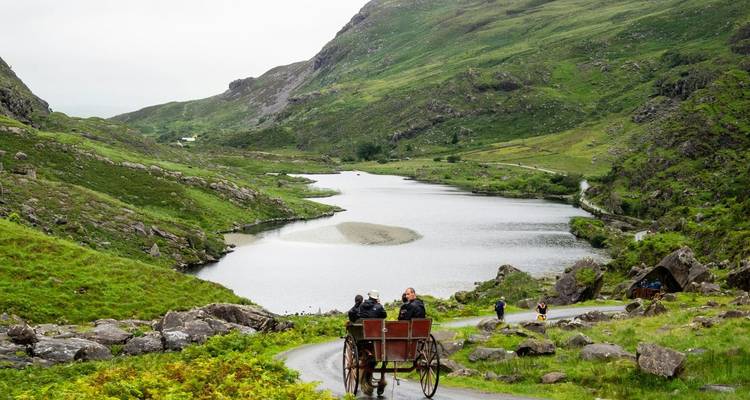 Couple se promenant dans une calèche tirée par des chevaux le long d'une vallée pittoresque à Killarney, en Irlande.