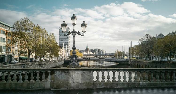 Vue de la rivière de Dublin et des bâtiments classiques sous un ciel nuageux.
