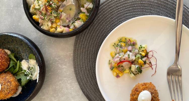 Variedad de platos de mariscos y acompañamientos presentados en una mesa con un ambiente moderno.