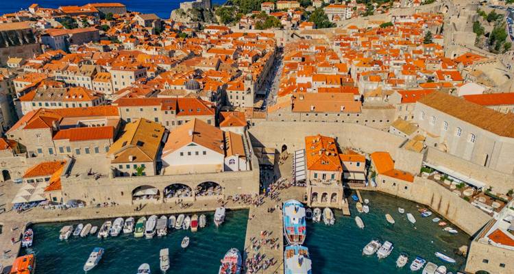 Vista aérea del casco antiguo de Dubrovnik con barcos en el puerto.