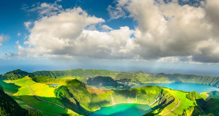 Vue aérienne panoramique des lacs jumeaux dans le cratère de Sete Cidades brillant d'émeraude et de turquoise sous des nuages spectaculaires.