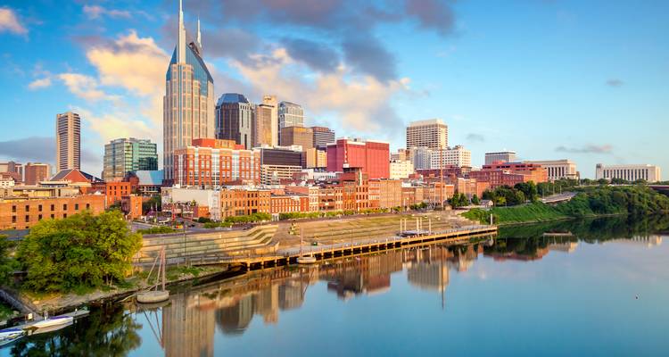 Lumière matinale sur les quais de Nashville avec le bâtiment AT&T 'Batman' se reflétant dans l'eau calme.