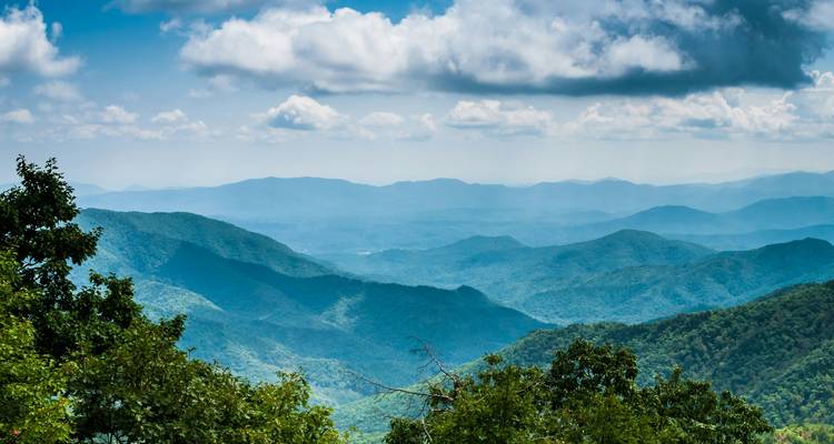 Geschichtete blaue Kämme der Appalachen, die sich unter einem teilweise bewölkten Himmel erstrecken.