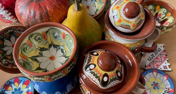 Macetas de arcilla decorativas y un par de frutas sobre una mesa.