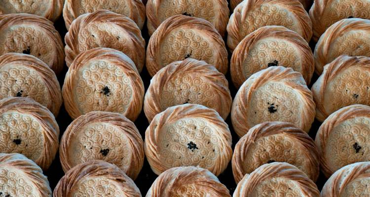 Filas de panes redondos tradicionales uzbekos con tops estampados