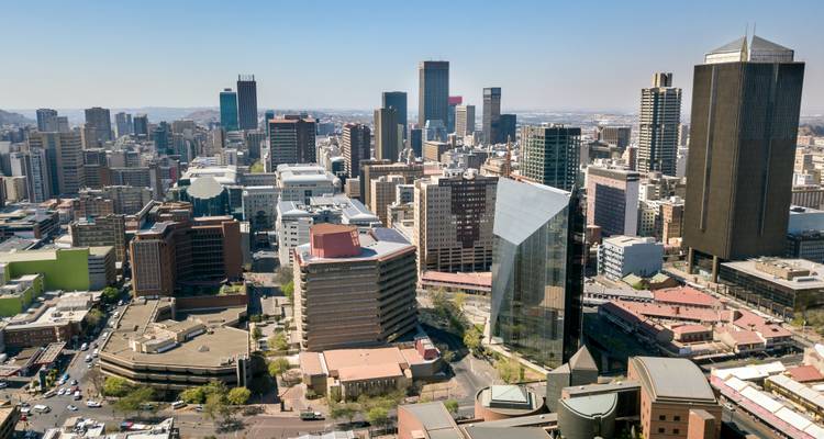 Skyline of a modern city with tall skyscrapers and a clear blue sky.