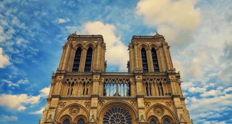 Vue rapprochée des tours jumelles de la cathédrale Notre-Dame contre un ciel bleu.