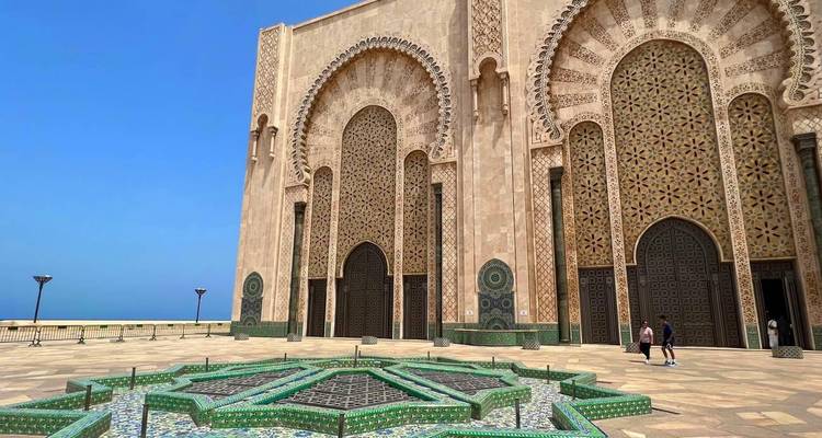 Personas caminando afuera de la Mezquita Hassan II en Casablanca.
