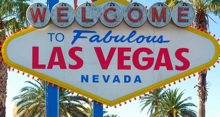 El clásico letrero de Bienvenidos a Las Vegas rodeado de palmeras.