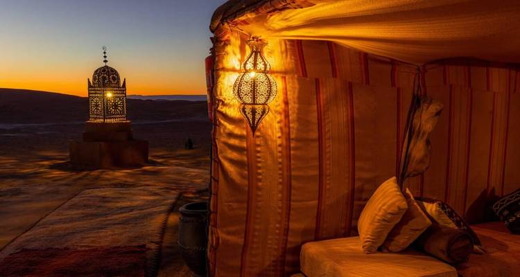 Intérieur de tente magnifiquement éclairé au coucher du soleil avec des lanternes